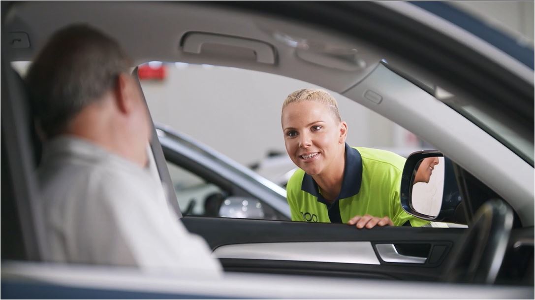 O'Brien® staff member talking to a man through a car window.